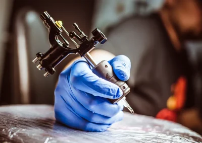 Tattoo artist wearing protective gloves