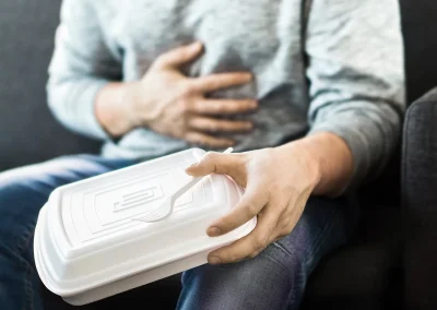 PERSON HOLDING STOMACH WITH FOOD POISONING AND STOMACH ACHE