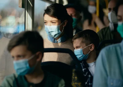 Mother and son sitting on bus in masks during a pandemic